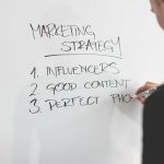 Marketing Expert Writing New Strategy on Whiteboard